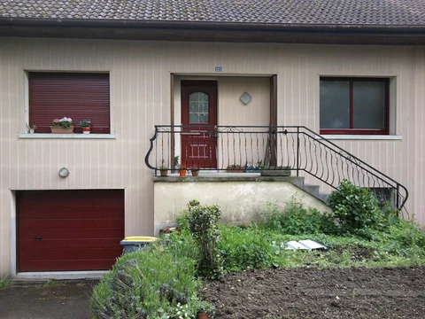 Façade de maison individuelle avec escalier extérieur menant à l'entrée principale au premier étage