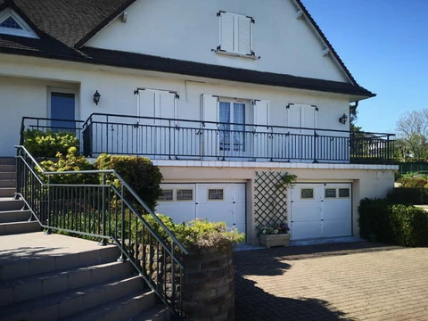 Extérieur résidentiel avec maison à étage, balcon et garage