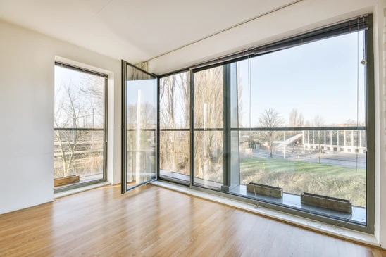 Intérieur moderne avec baie vitrée coulissante donnant sur terrasse face à la mer