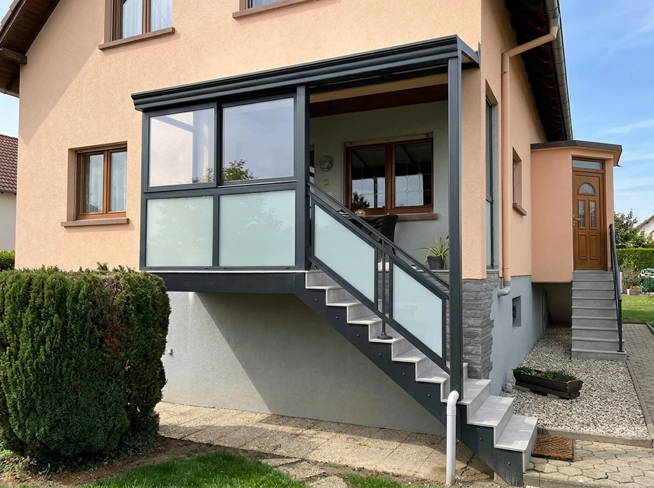 Terrasse extérieure d'une maison avec pergola bioclimatique à lames orientables en aluminium anthracite
