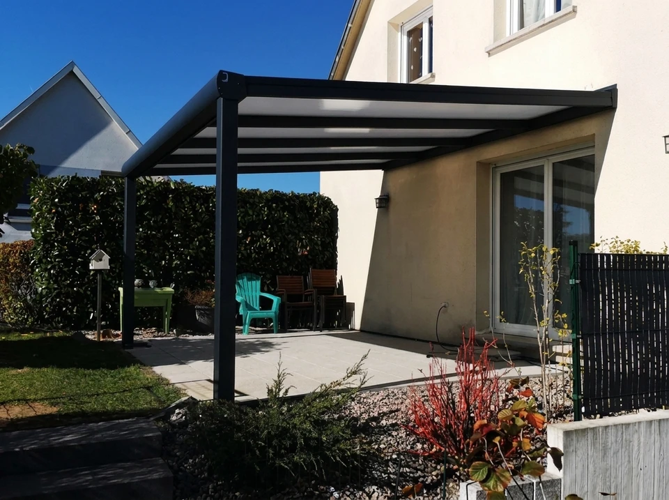 Scène extérieure montrant une pergola moderne en cours de construction ou terminée, photographiée en contre-plongée sous un ciel bleu dégagé