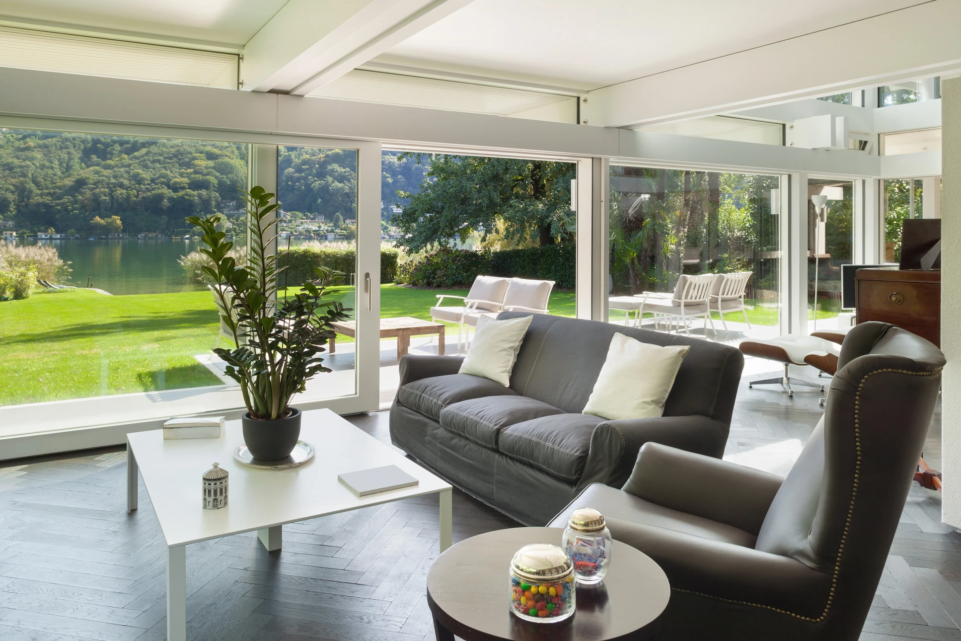 Extension moderne avec véranda lumineuse, salon confortable avec canapés cuir marron, table basse en bois